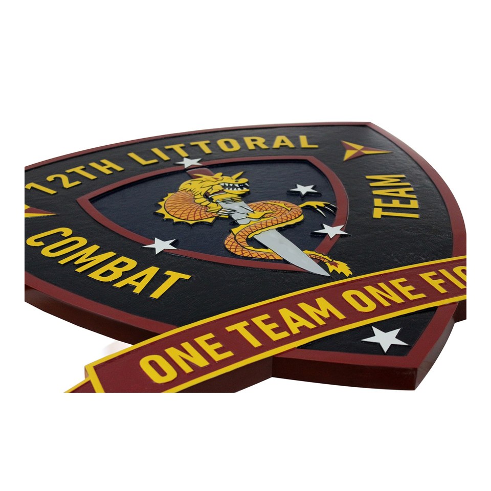 Angled view of a 12th Littoral Combat Team crest plaque with gold lettering and a red One Team One Fight scroll.